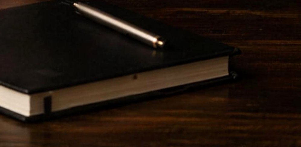 Notitieboek met pen op donker hout